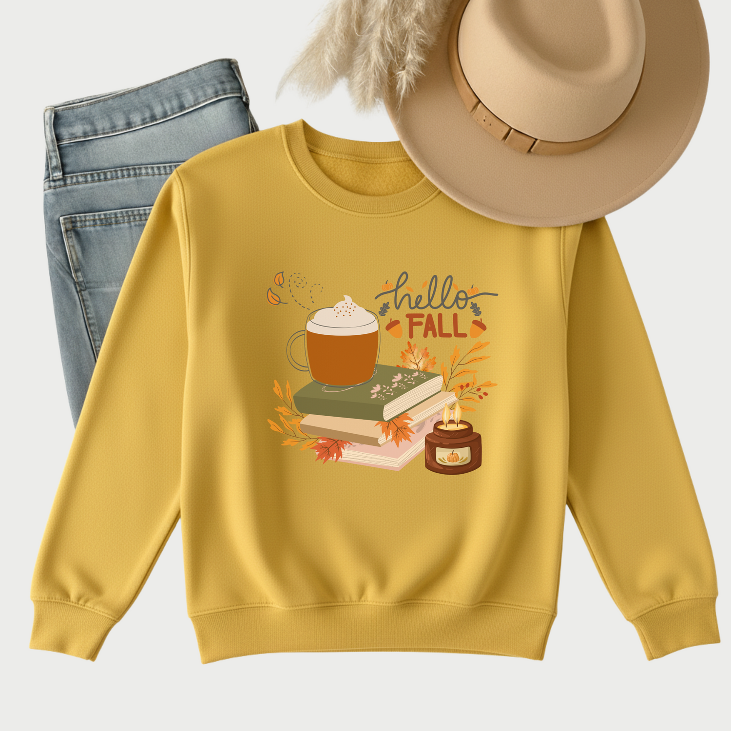 Flat lay of cozy fall graphic sweatshirts in autumn tones (yellow, orange, black, grey), styled with jeans and accessories – trendy fall outfit mockup.