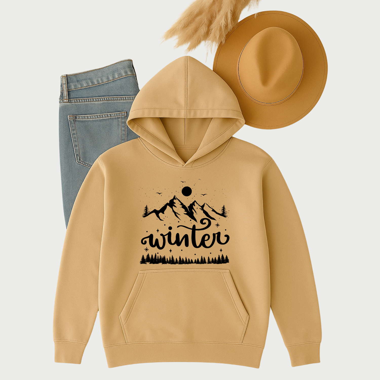 Flat lay of a sand-colored hoodie sweatshirt with blue jeans and a tan hat, styled for a cozy winter outfit.