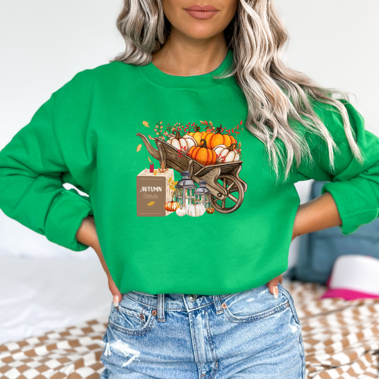 Person wearing a green sweatshirt with autumn-themed design