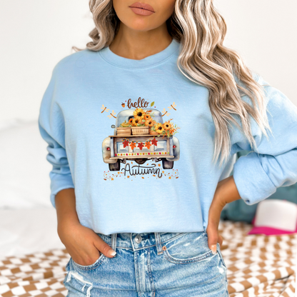 Light blue sweatshirt with autumn-themed design worn by a person.