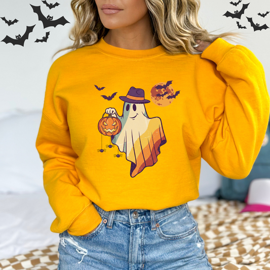Person wearing a yellow Halloween-themed sweatshirt with a ghost and pumpkin design A vintage-style illustration of a friendly ghost wearing a hat and holding a glowing jack-o'-lantern. In the background, there is a large moon, with bats and spiders visible.