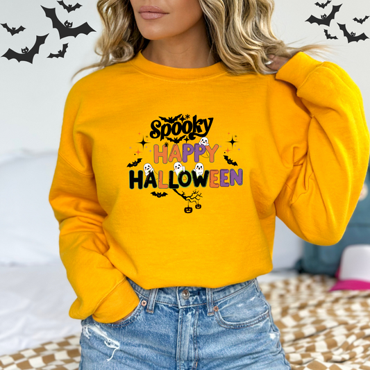 Person wearing a yellow Halloween-themed sweatshirt with text and graphics A fun illustration with the words "Spooky" at the top and "Happy Halloween" below it. The letters are in a playful, stylized font. Cute cartoon ghosts are peeking out from the "P" and "O" in "Happy" and "Halloween." Bats are flying around the text, and two small jack-o'-lanterns hang from a tree branch at the bottom.