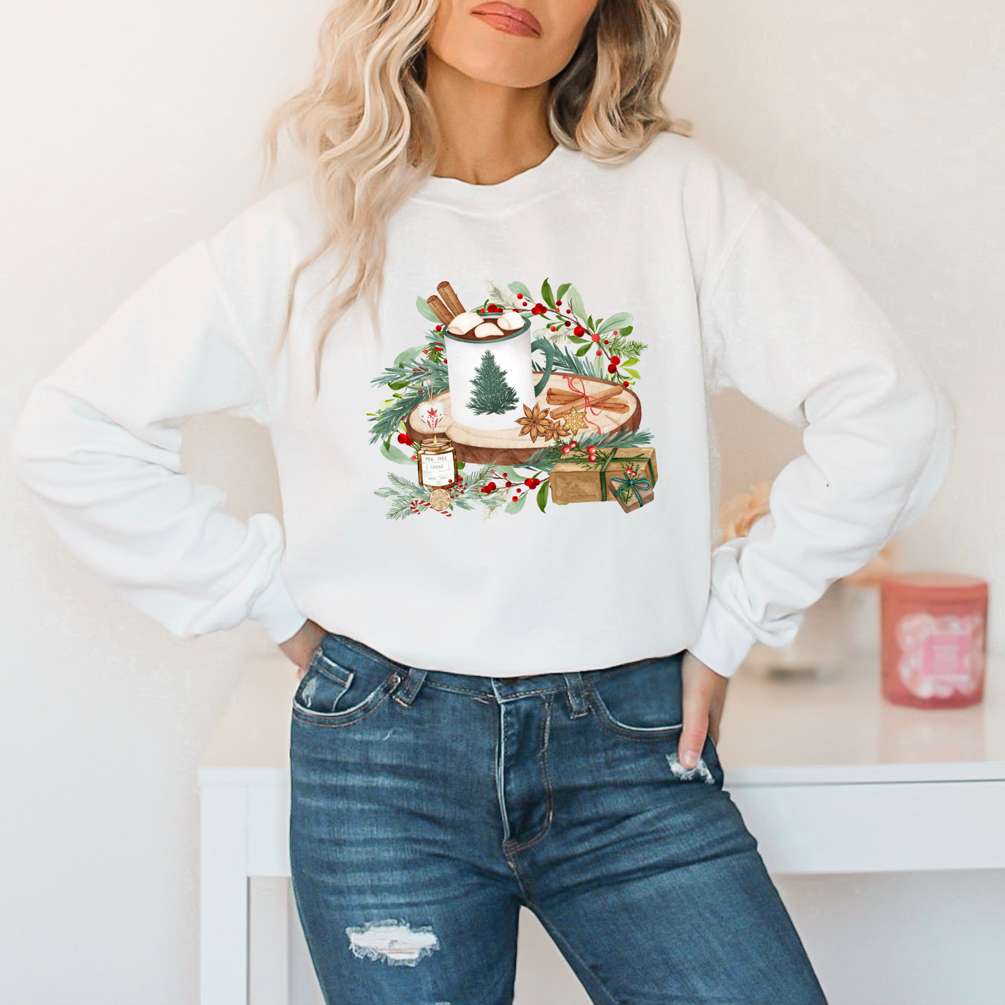 Person wearing a white sweatshirt with a festive design and blue jeans.